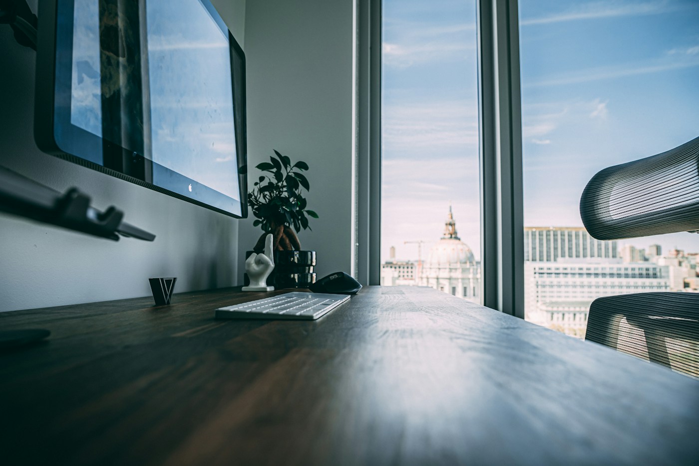 A desktop workstation beside a bright office window